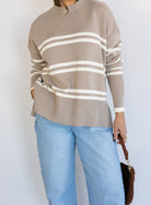 Woman wearing the Lucille Sweater in Taupe, an oversized taupe and cream striped crewneck sweater