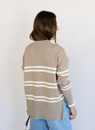 Woman wearing the Lucille Sweater in Taupe, an oversized taupe and cream striped crewneck sweater