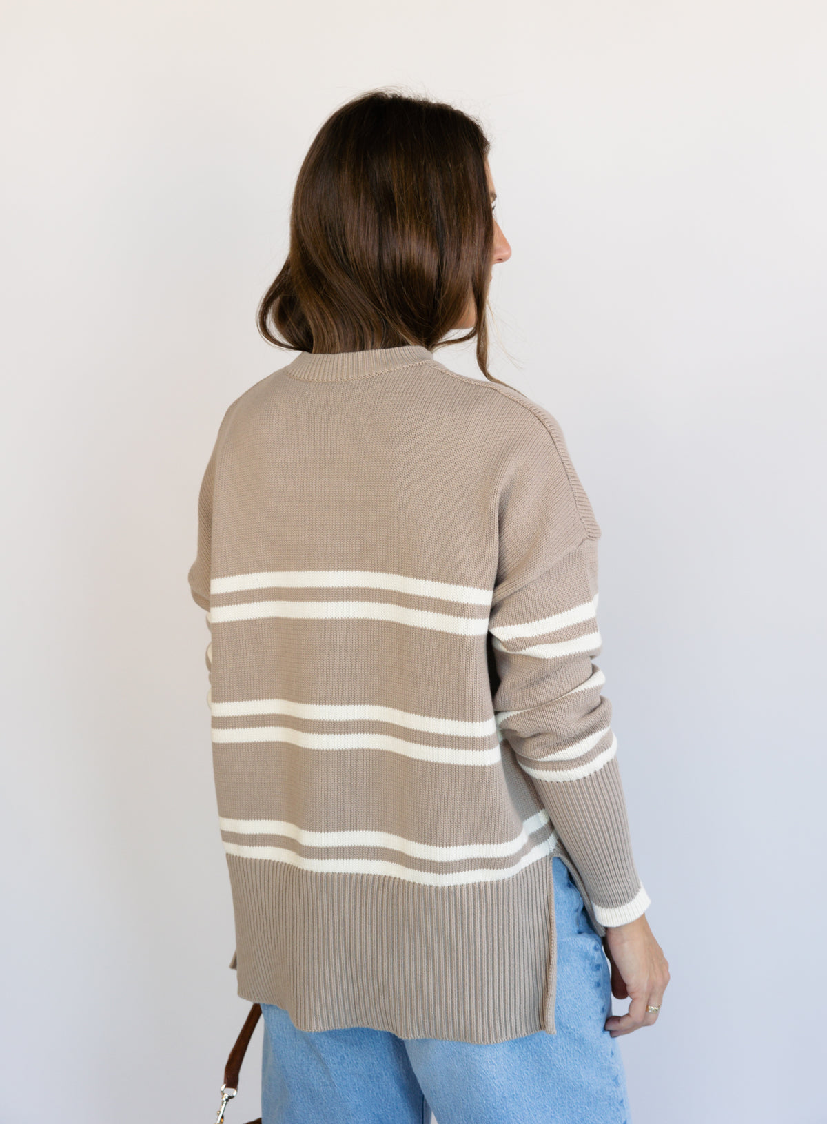 Woman wearing the Lucille Sweater in Taupe, an oversized taupe and cream striped crewneck sweater