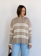 Woman wearing the Lucille Sweater in Taupe, an oversized taupe and cream striped crewneck sweater