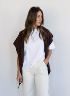 Woman wearing the Wrenley Warm Shawl Scarf in Brown, a chocolate brown knit triangle shawl