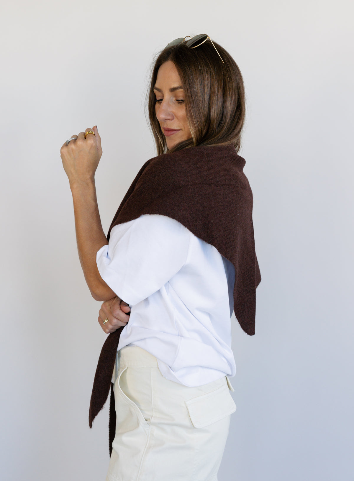 Woman wearing the Wrenley Warm Shawl Scarf in Brown, a chocolate brown knit triangle shawl