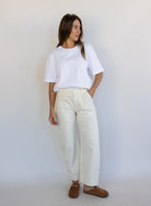 Woman wearing Favorite Daughter The Major Pant, winter white mid-rise barrel-leg cotton pants