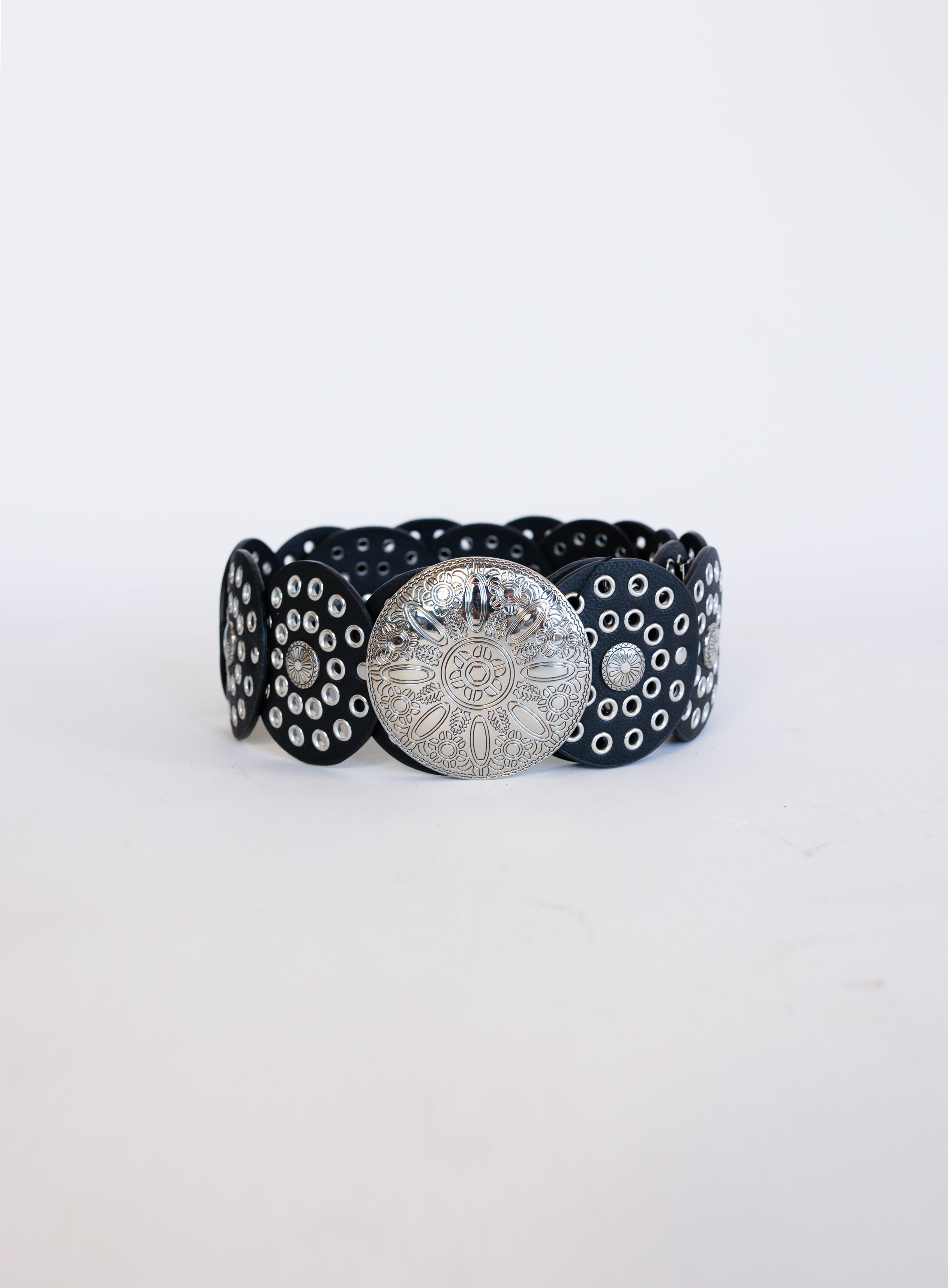 Greta Wide Western Belt in Black, a wide black disc belt with silver grommets and a concho buckle
