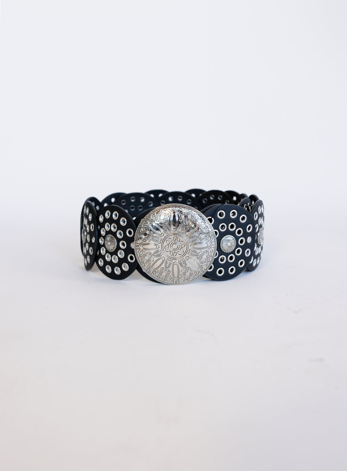 Greta Wide Western Belt in Black, a wide black disc belt with silver grommets and a concho buckle