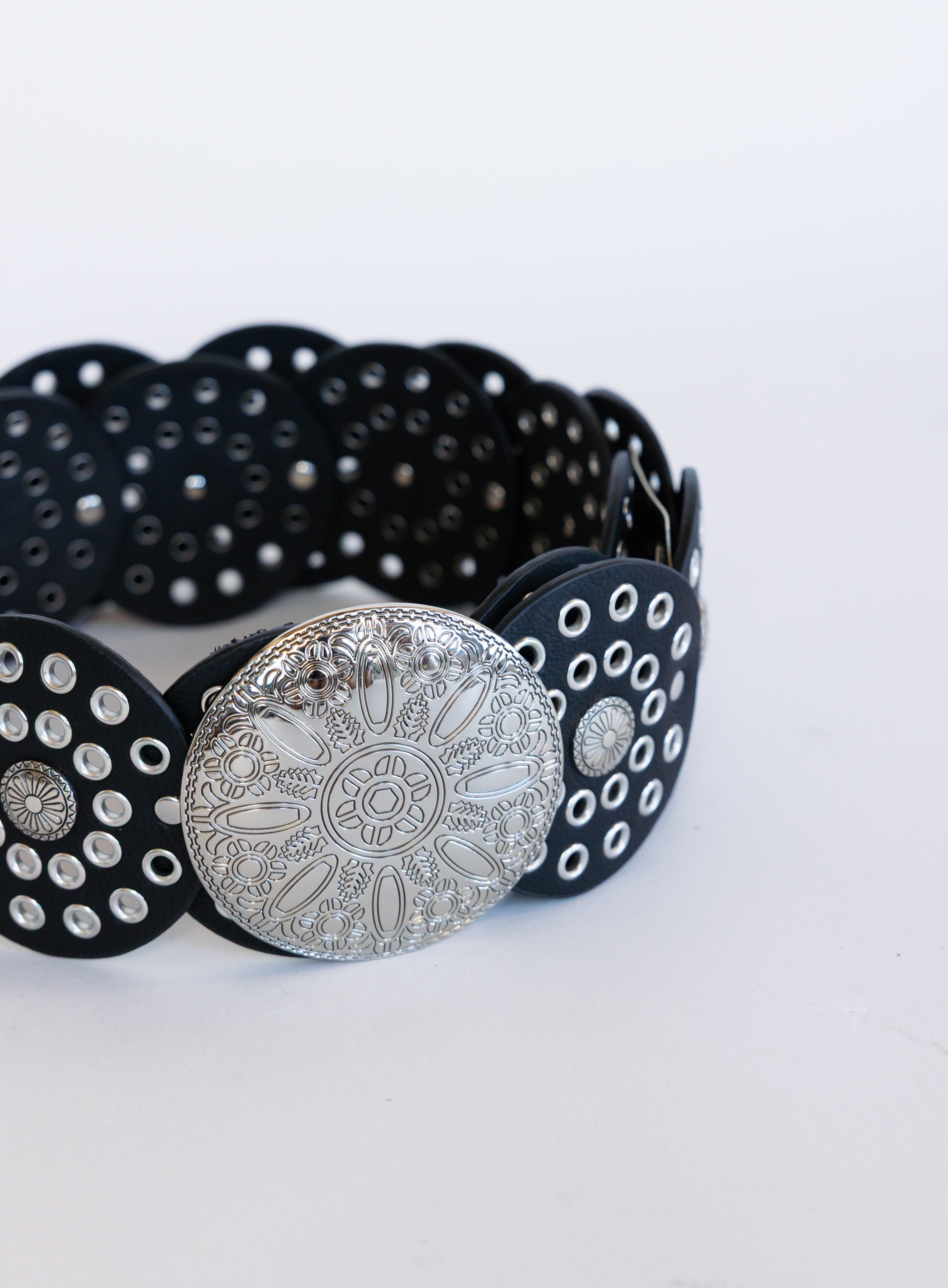Greta Wide Western Belt in Black, a wide black disc belt with silver grommets and a concho buckle