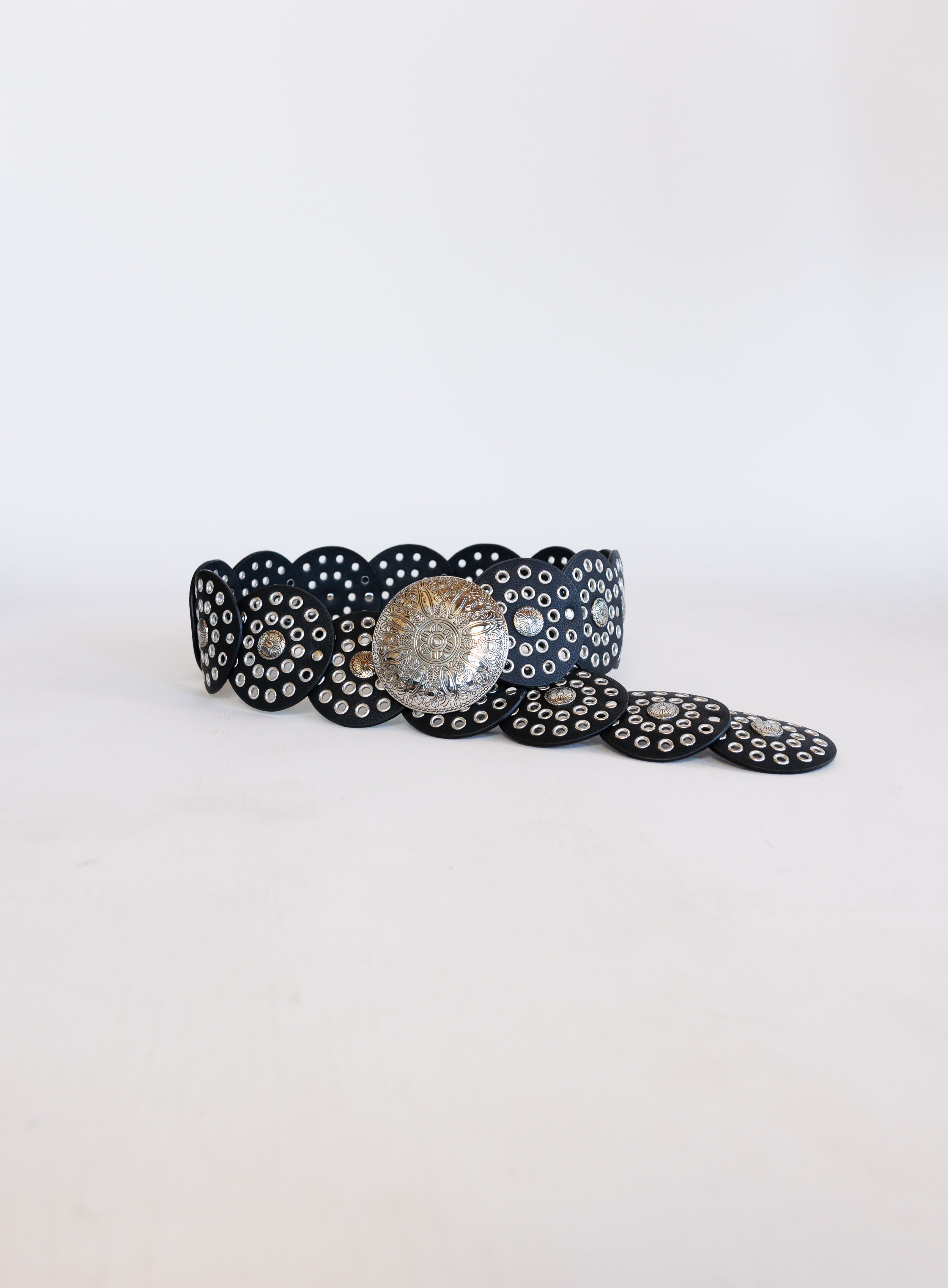 Greta Wide Western Belt in Black, a wide black disc belt with silver grommets and a concho buckle