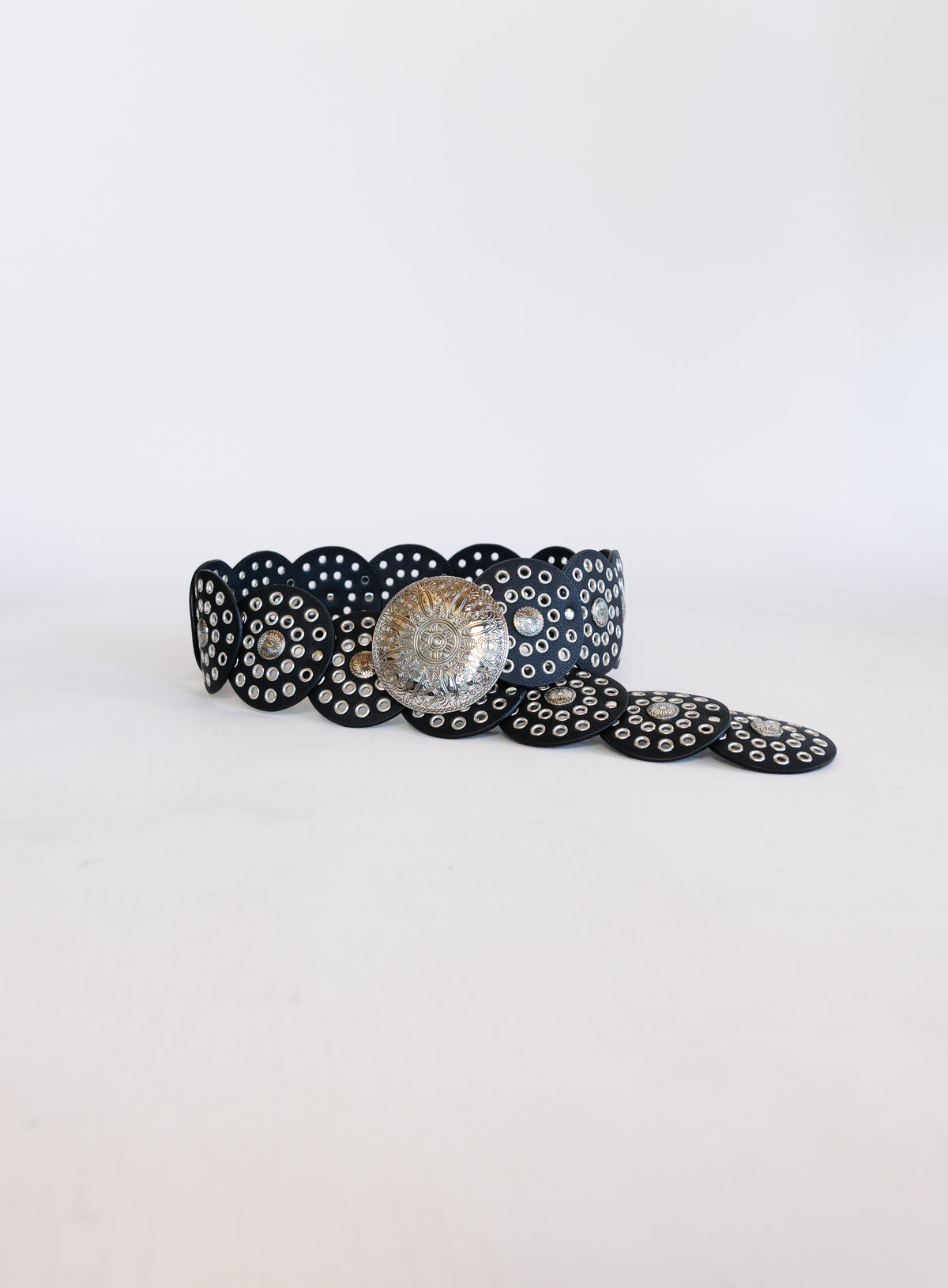 Greta Wide Western Belt in Black, a wide black disc belt with silver grommets and a concho buckle