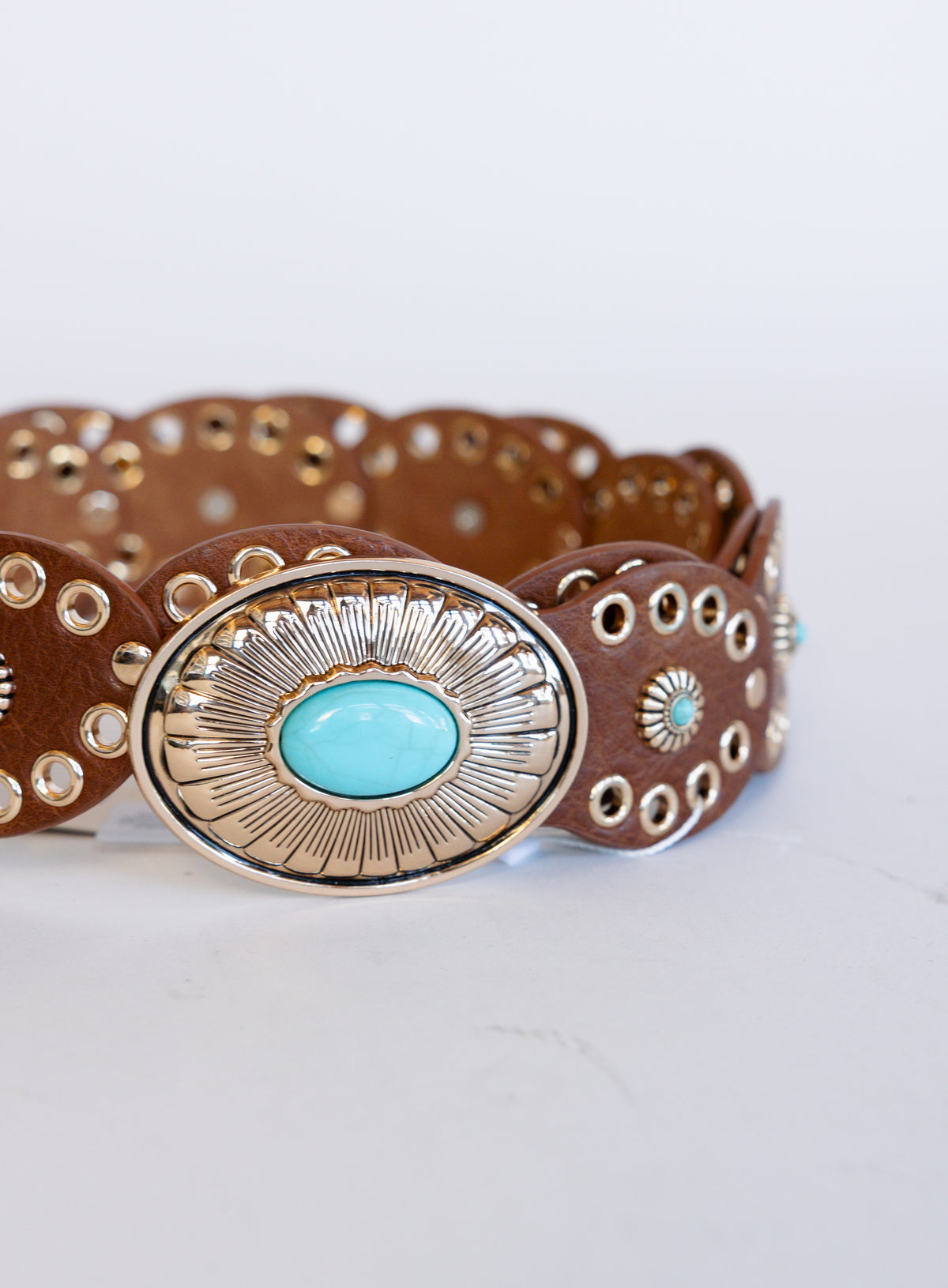 Mirabel Turquoise Disc Belt, a tan disc belt with silver grommets and a turquoise-tone buckle