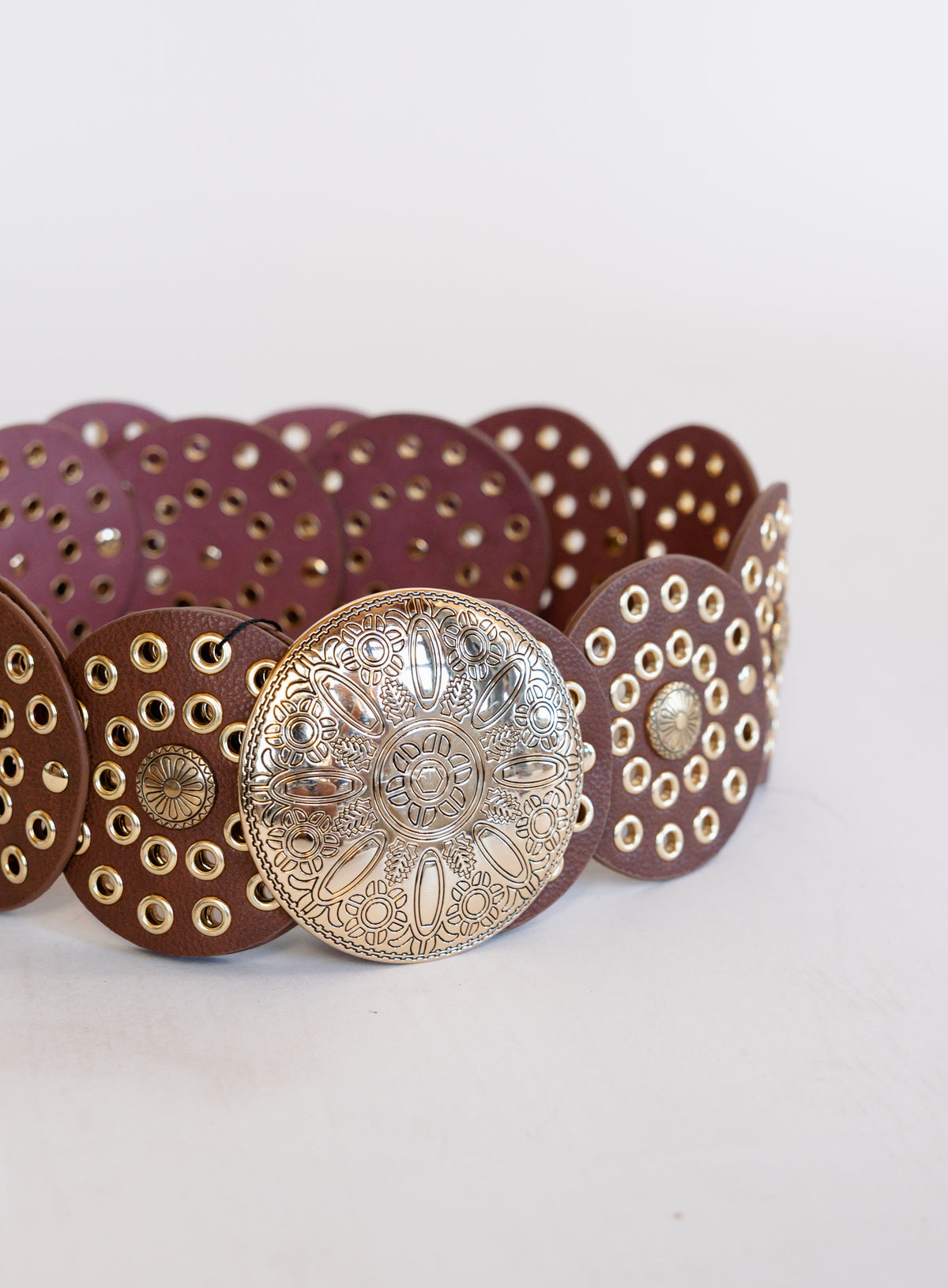 Greta Wide Western Belt in Cognac, a wide cognac disc belt with silver grommets and a concho buckle
