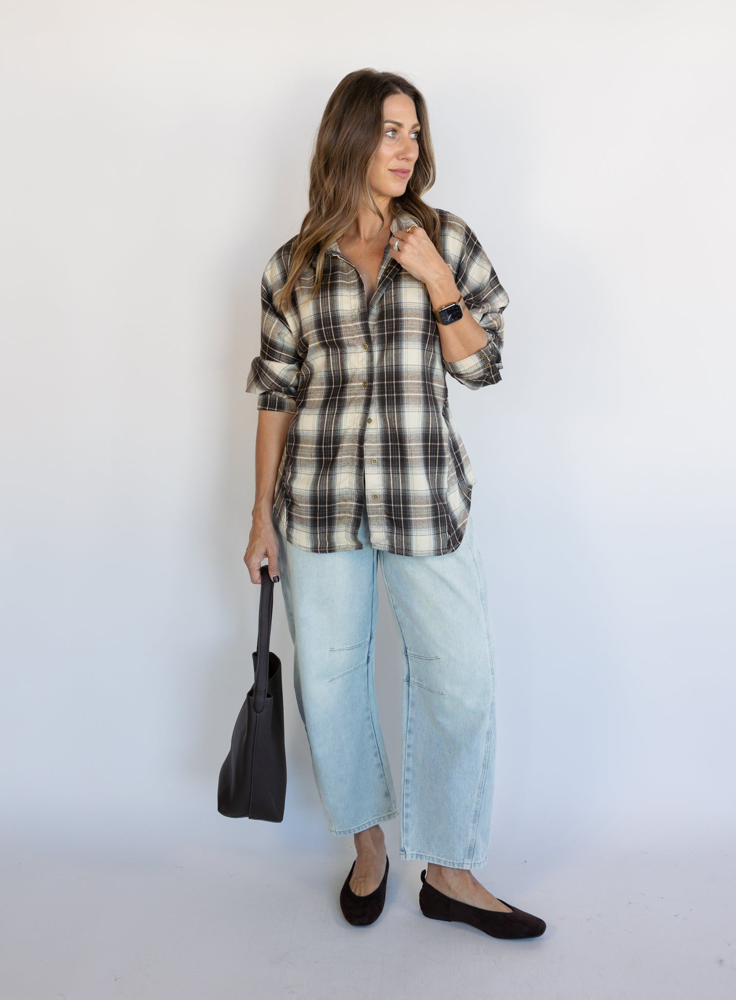 Woman wearing the Heartloom Bobbie Shirt, a black, cream and grey plaid oversized button-down