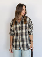 Woman wearing the Heartloom Bobbie Shirt, a black, cream and grey plaid oversized button-down