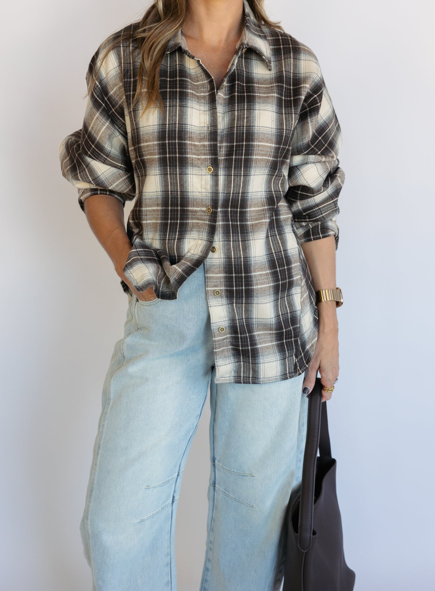 Woman wearing the Heartloom Bobbie Shirt, a black, cream and grey plaid oversized button-down