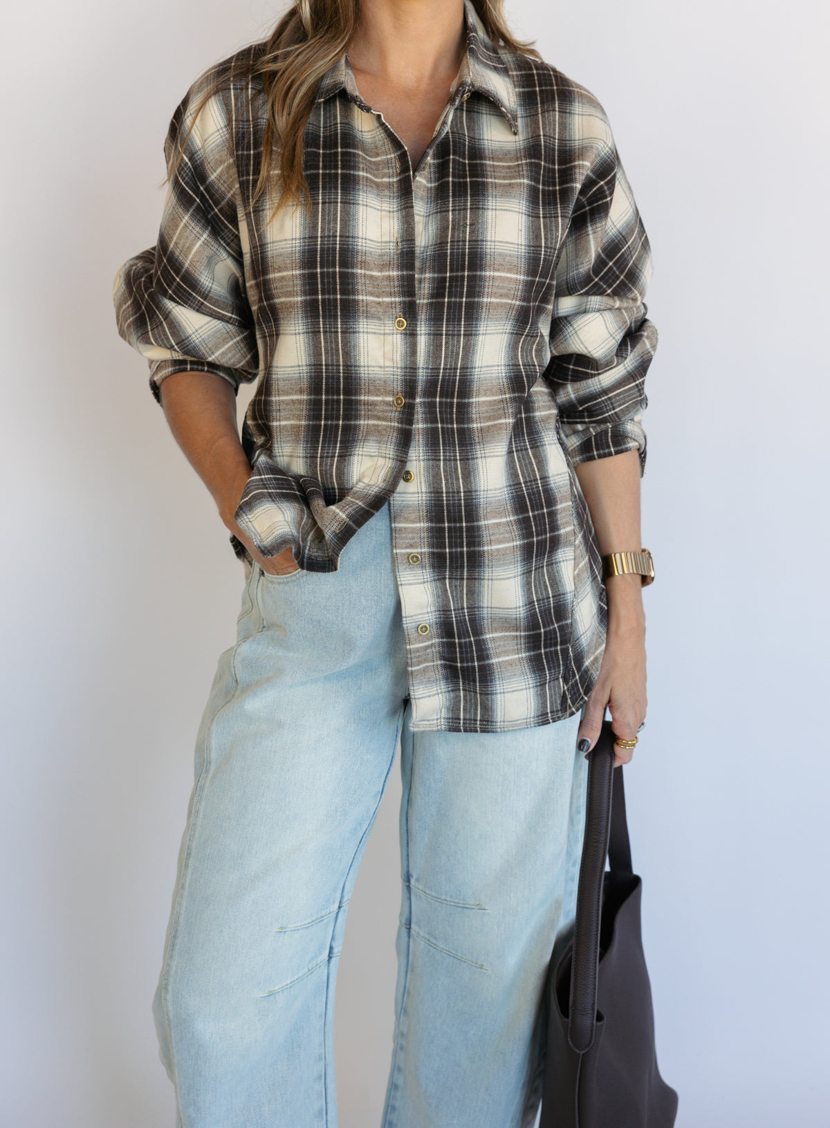 Woman wearing the Heartloom Bobbie Shirt, a black, cream and grey plaid oversized button-down