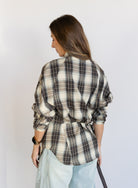 Woman wearing the Heartloom Bobbie Shirt, a black, cream and grey plaid oversized button-down