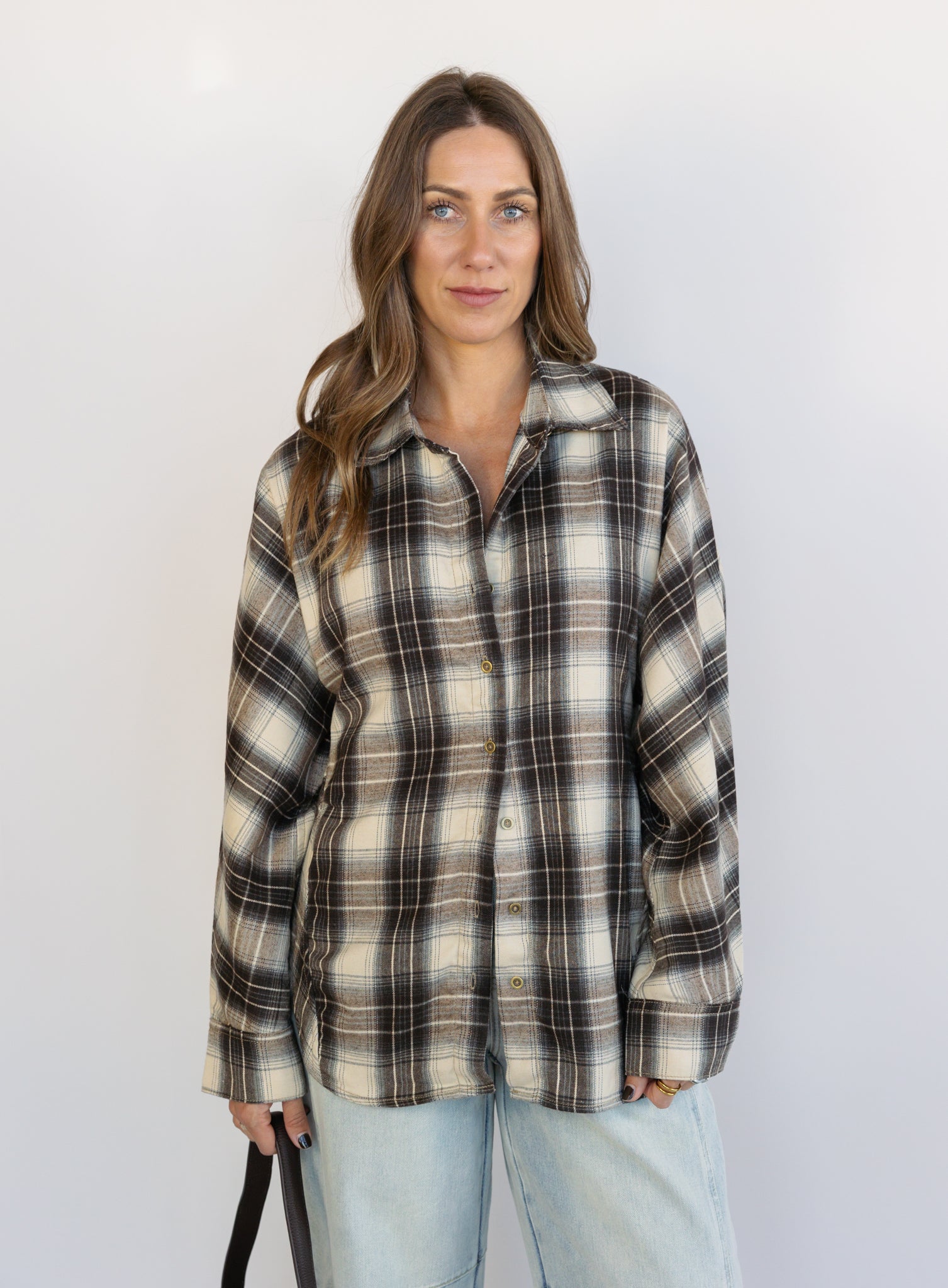 Woman wearing the Heartloom Bobbie Shirt, a black, cream and grey plaid oversized button-down