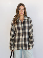 Woman wearing the Heartloom Bobbie Shirt, a black, cream and grey plaid oversized button-down