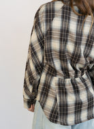 Woman wearing the Heartloom Bobbie Shirt, a black, cream and grey plaid oversized button-down