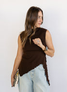 Woman wearing the Coralie Ruffle Trim Sweater Tank, a chocolate brown mock neck knit tank with a ruffle hem