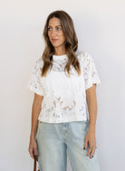 Woman wearing the Lillia Lace Floral Tee, a sheer white mesh tee with floral embroidery