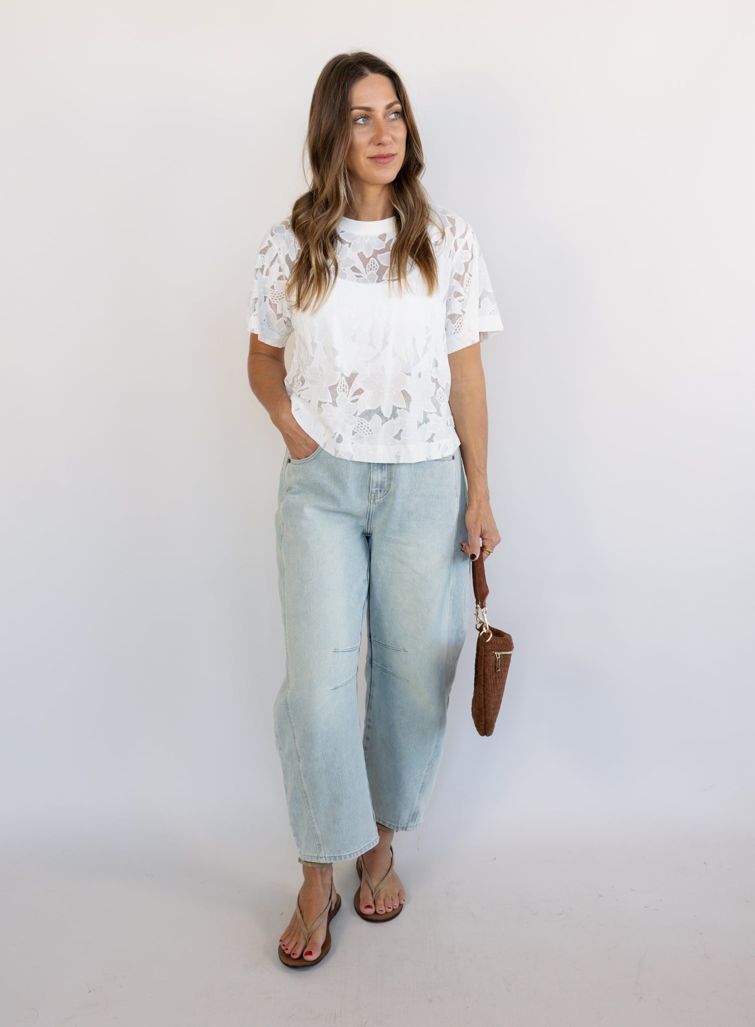 Woman wearing the Lillia Lace Floral Tee, a sheer white mesh tee with floral embroidery