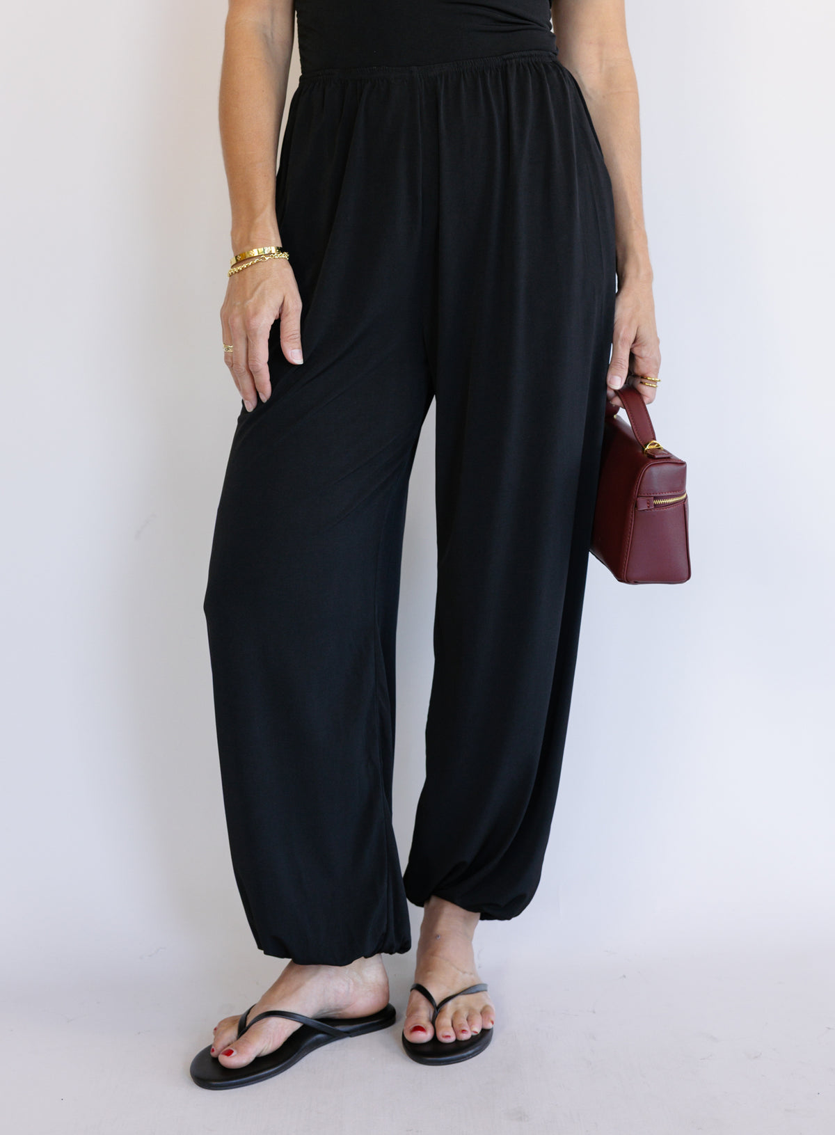 Woman wearing the Azalea Balloon Pants, black lightweight balloon-leg pants with gathered ankle cuffs