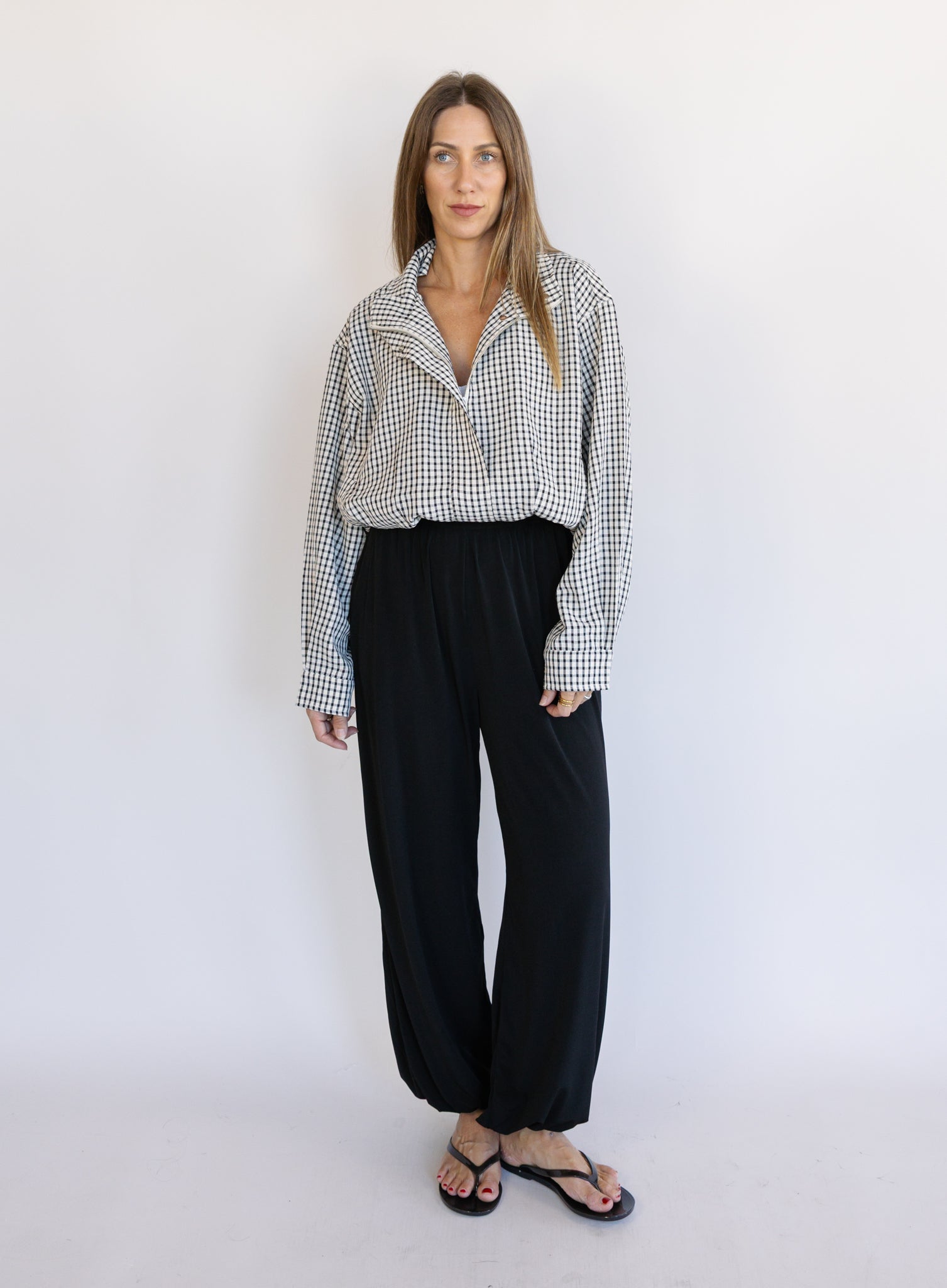 Woman wearing the Calliope Funnel Neck Bomber Jacket, a black and white gingham zip-up bomber