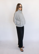 Woman wearing the Calliope Funnel Neck Bomber Jacket, a black and white gingham zip-up bomber