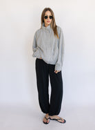Woman wearing the Calliope Funnel Neck Bomber Jacket, a black and white gingham zip-up bomber