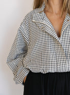 Woman wearing the Calliope Funnel Neck Bomber Jacket, a black and white gingham zip-up bomber