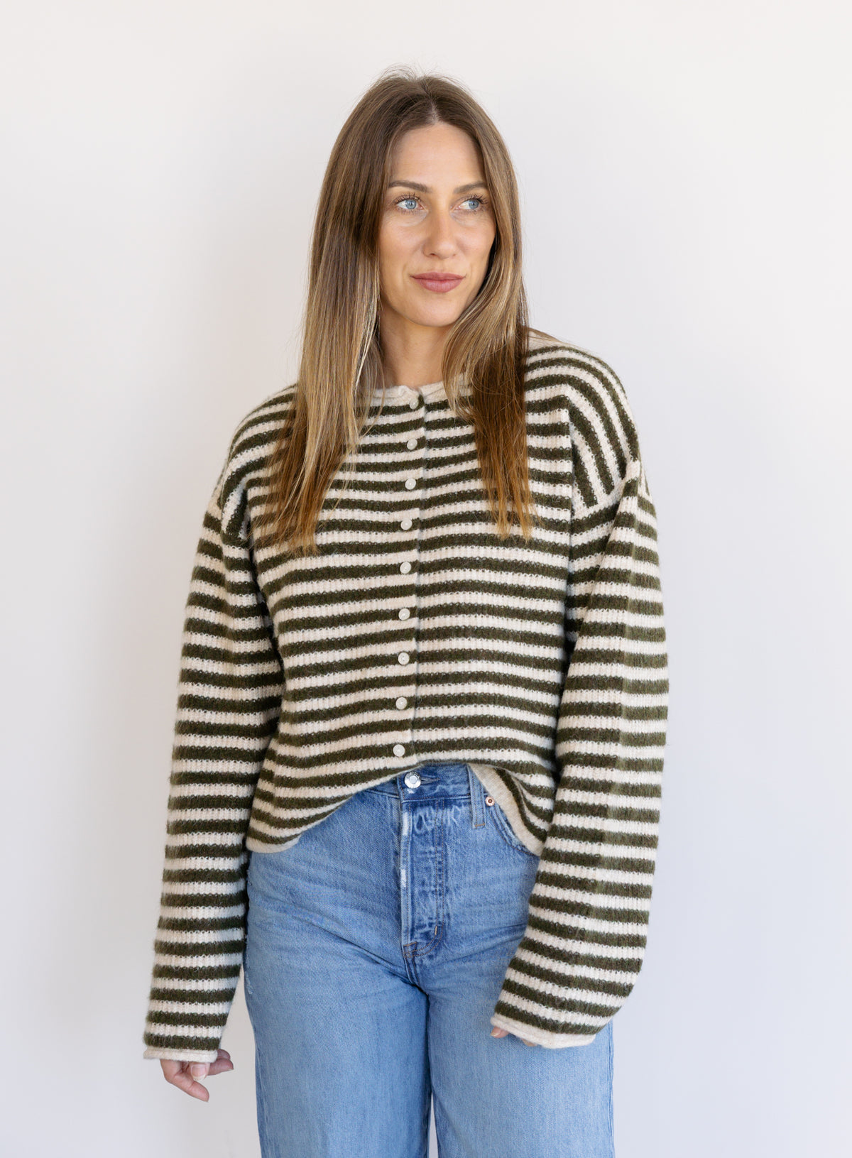 Woman wearing the Marlowe Striped Cardigan, an olive and cream striped button-front cardigan