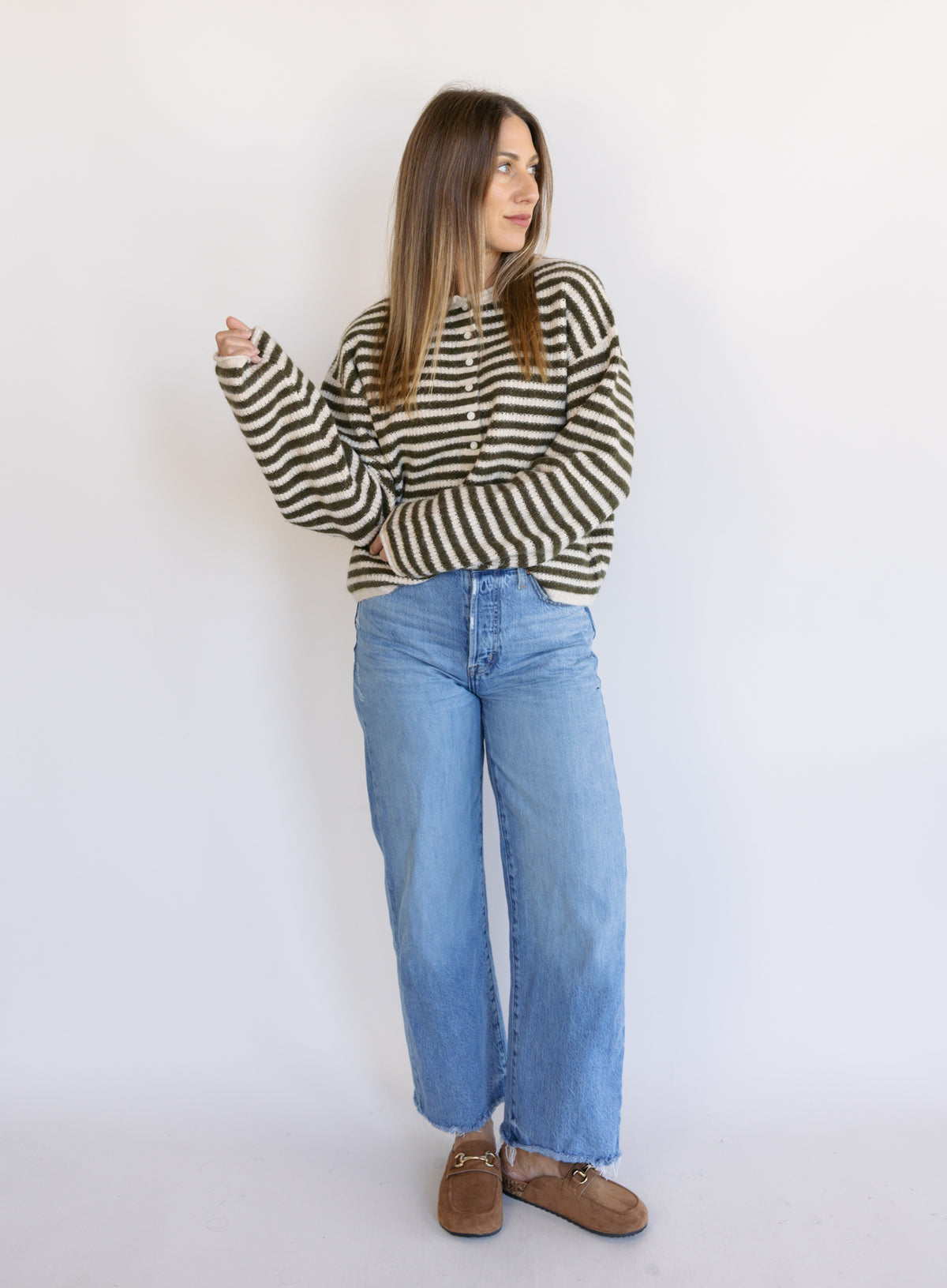 Woman wearing the Marlowe Striped Cardigan, an olive and cream striped button-front cardigan