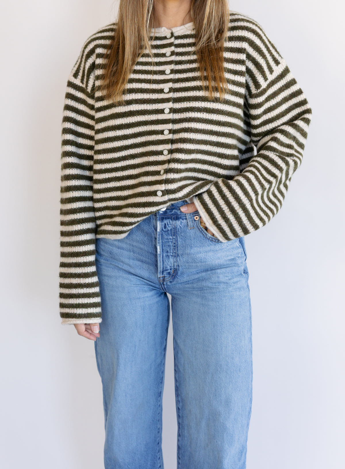 Woman wearing the Marlowe Striped Cardigan, an olive and cream striped button-front cardigan
