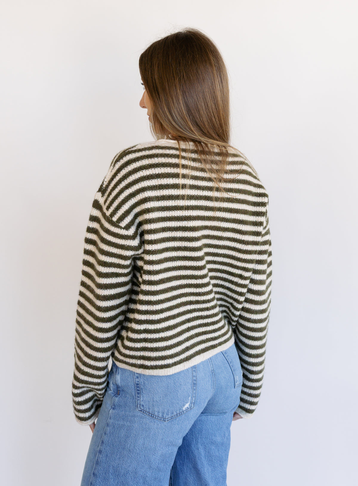Woman wearing the Marlowe Striped Cardigan, an olive and cream striped button-front cardigan