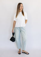 Woman wearing the Lakelyn Cinched Top, a white structured knit crewneck tee cinched at the waist
