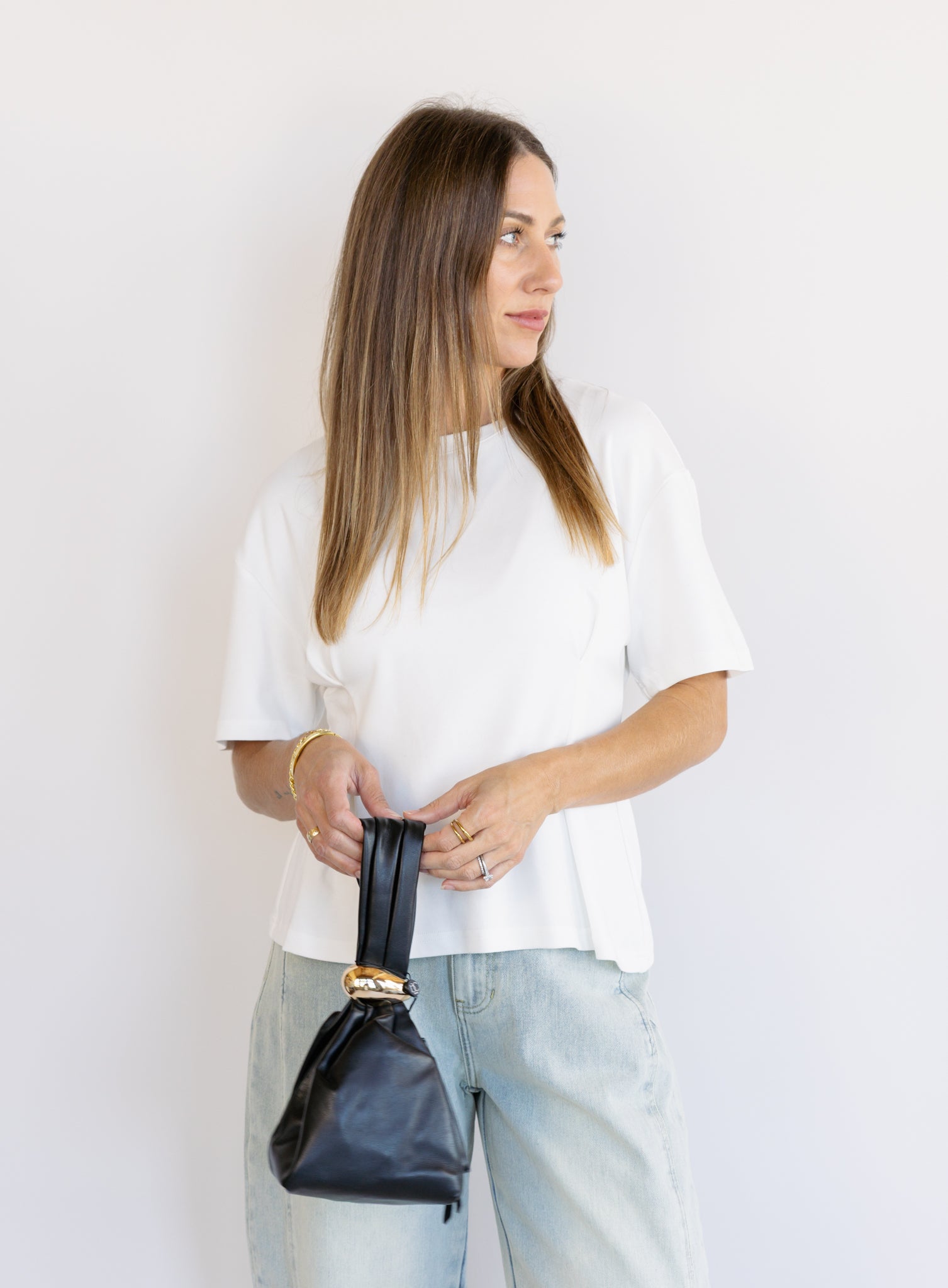 Woman wearing the Lakelyn Cinched Top, a white structured knit crewneck tee cinched at the waist