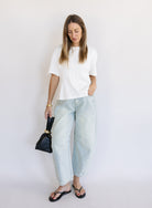 Woman wearing the Lakelyn Cinched Top, a white structured knit crewneck tee cinched at the waist
