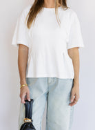 Woman wearing the Lakelyn Cinched Top, a white structured knit crewneck tee cinched at the waist