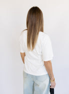 Woman wearing the Lakelyn Cinched Top, a white structured knit crewneck tee cinched at the waist