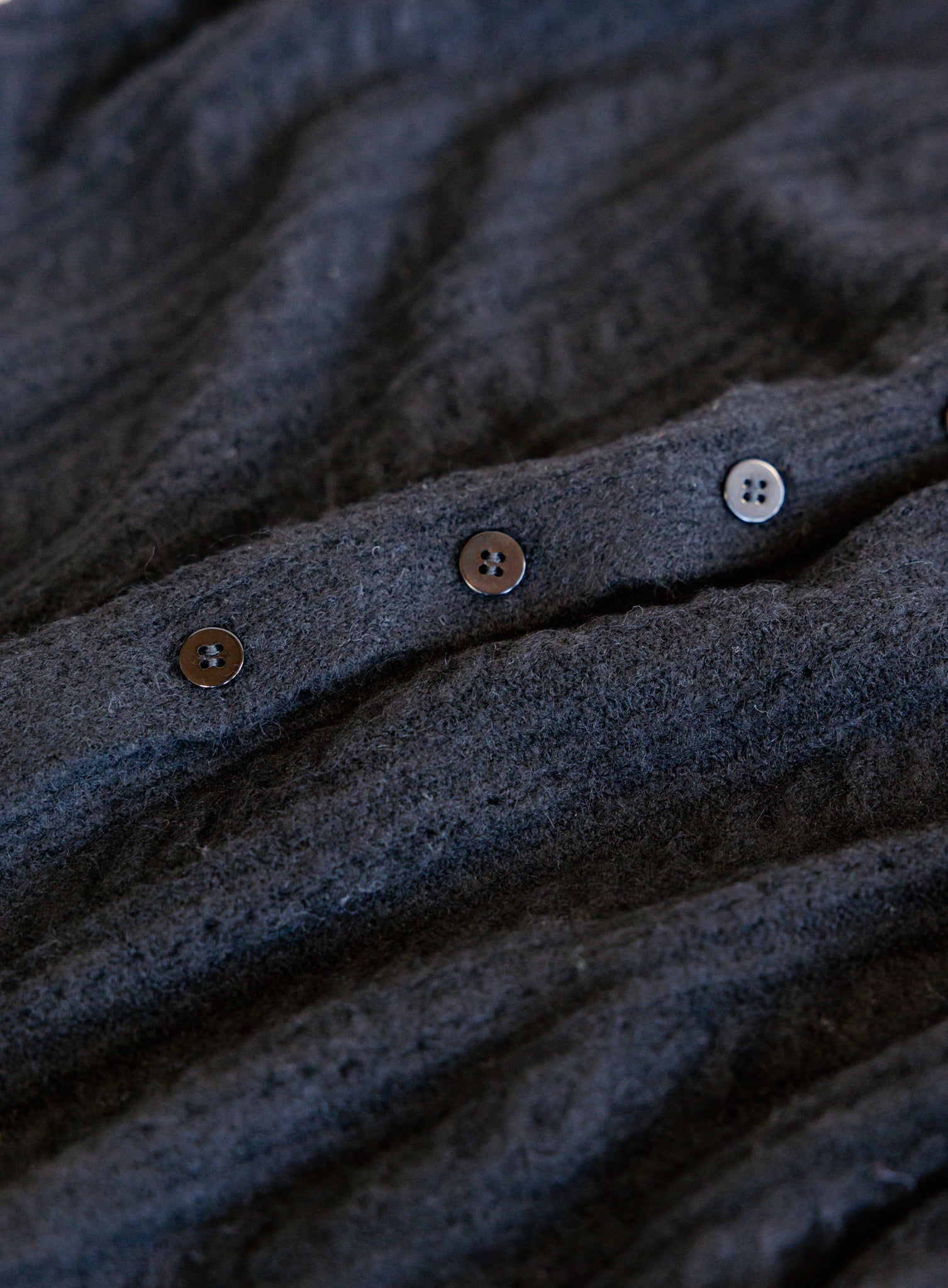 Woman wearing the Z Supply Medina Pointelle Cardigan, a black cable pointelle knit button-front cardigan