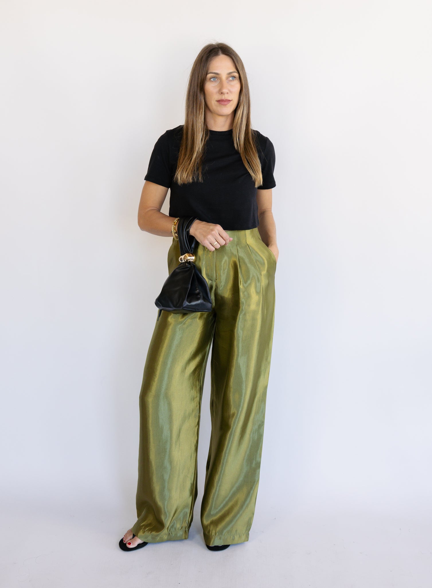 Woman wearing the Sophia Pleated Pants, olive high-rise wide-leg pleated pants