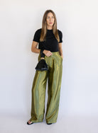 Woman wearing the Sophia Pleated Pants, olive high-rise wide-leg pleated pants