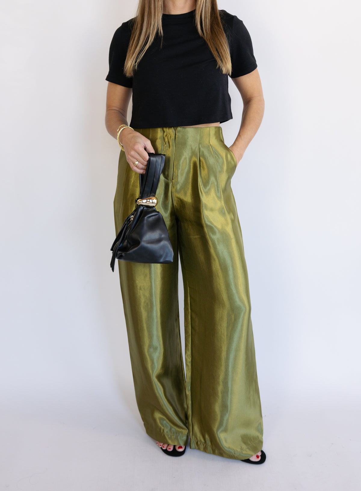 Woman wearing the Sophia Pleated Pants, olive high-rise wide-leg pleated pants