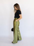 Woman wearing the Sophia Pleated Pants, olive high-rise wide-leg pleated pants