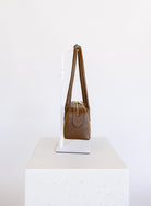 Jonava Suede Bag in Espresso, an elongated suede shoulder bag with gold zipper pulls