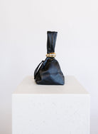 Celine Evening Bag, a slouchy black pouch with a gold cuff handle