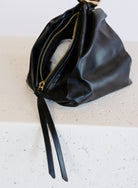 Celine Evening Bag, a slouchy black pouch with a gold cuff handle