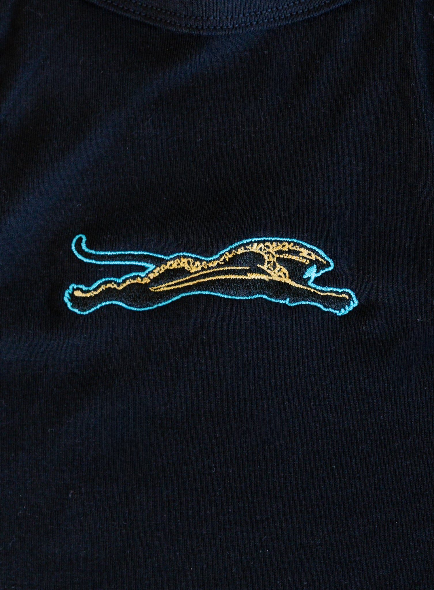 Jags Embroidered Crop Tank, a jet black high-neck crop tank with a teal and gold embroidered jaguar