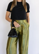 Woman wearing the Sophia Pleated Pants, olive high-rise wide-leg pleated pants