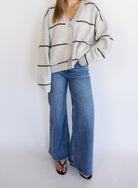 Woman wearing the Juno Striped Knit Cardigan, a mushroom knit cardigan with chocolate stripes and a V-neck